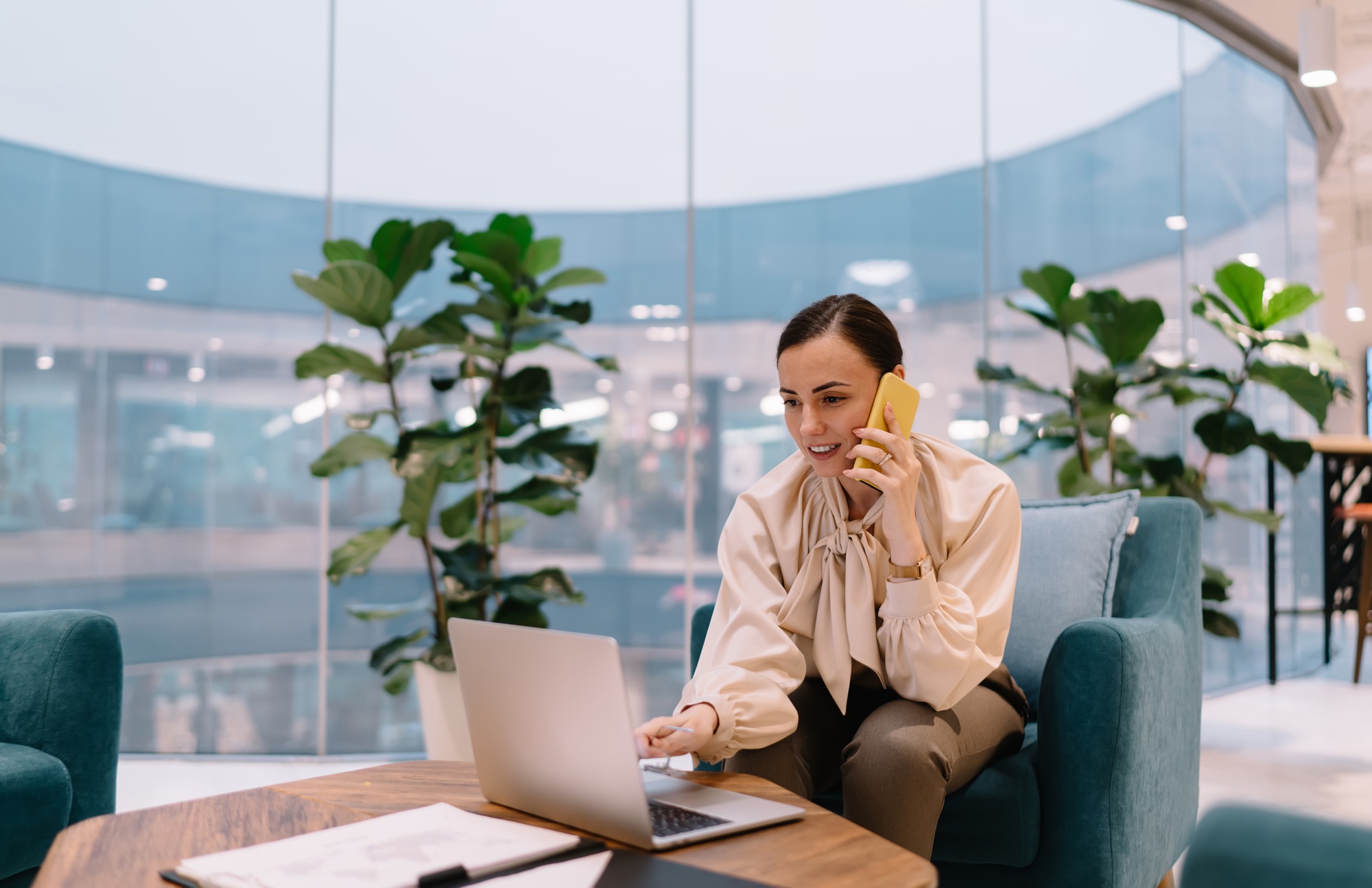 Smiling woman working on laptop in modern office